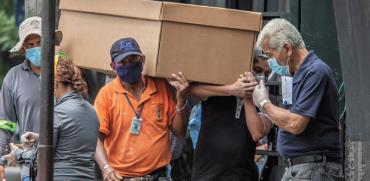 אזרחי אקוודור נושאים ארון קבורה מקרטון בדרך לבית קברות בגוואייאקיל / צילום: Luis Perez, Associated Press