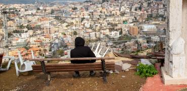 צעיר ערבי-ישראלי צופה על הישוב הערבי אום אל פאחם. כ–50% מהמשפחות הערביות נמצאות מתחת לקו העוני והתלמידים הערבים מופלים בתקציבים גם במערכת החינוך כולה / צילום: Oded Balilty, Associated Press