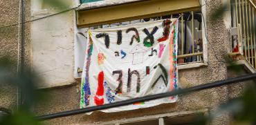 שלט עידוד שנתלה מחוץ לחלון דירה בארץ בצל הסגר / צילום: שלומי יוסף, גלובס