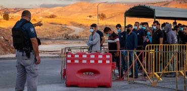 פועלים פלסטינים ממתינים במחסום / צילום: Oded Balilty, Associated Press