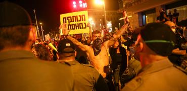 מפגין מסמן עצור בהפגנה בבלפור / צילום: Oded Balilty, Associated Press