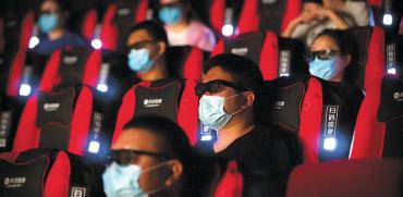 צופים בבייג’ינג, השבוע. בתי הקולנוע מורשים למלא עד 30% מהאולם  / צילום: Mark Schiefelbein, Associated Press