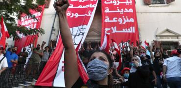 מפגינים מול משרד החוץ בביירות, שנפרץ ביום שבת. על השלטים: "ביירות בירת המהפכה" / צילום: Bilal Hussein, Associated Press