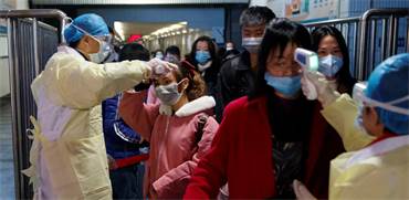 צוותים רפואיים מודדים טמפרטורות גוף של נוסעים ביציאה מרכבת בג'יאנג' בסין על רקע התפשטות נגיף הקורונה / צילום: Thomas Peter, רויטרס