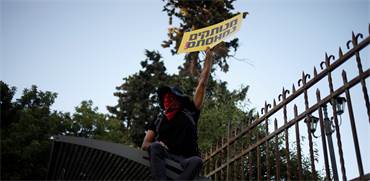 מפגין על גדר מול מעון רה"מ נתניהו / צילום: Ariel Schalit, Associated Press
