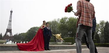 זוג סיני מצטלם לתמונות חתונה בפארק העולמי בבייג'ינג / צילום: Ng Han Guan, Associated Press