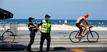 שוטרים בחוף הים בתל אביב לפני כניסת יום הכיפורים / צילום: Corinna Kern, רויטרס