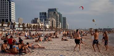 אנשים מבלים בים בתל אביב בזמן גל החום שפקד את המדינה / צילום: Oded Balilty, AP