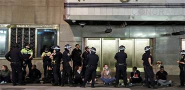 שוטרים עומדים מחוץ לאולם הופעות עם עצורים מההפגנות / צילום: Seth Wenig, AP