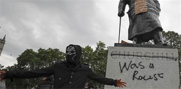 מפגין מול פסל וינסטון צ'רצ'יל שהושחת / צילום: Frank Augstein , Associated Press
