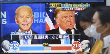 טראמפ וביידן על מסך בטוקיו. יפן תיישר קו עם כל תוצאה שהיא / צילום: Koji Sasahara, AP