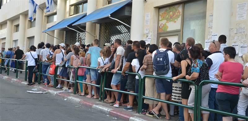 מהגרי עבודה מחכים בתור לכניסה ללשכת האוכלוסין והגירה בתל-אביב / צילום: תמר מצפי