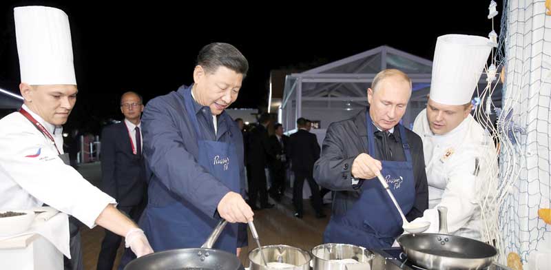 הנשיאים פוטין ושי מכינים פנקייקים / צילום: רויטרס