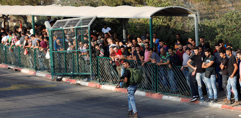 פועלים פלסטינים שמחכים להיכנס לאזור התעשייה בברקן /צילום: רויטרס
