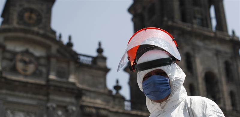 עובד משרד הבריאות מחטא את רובע העסקים של מקסיקו סיטי / צילום: Rebecca Blackwell, AP
