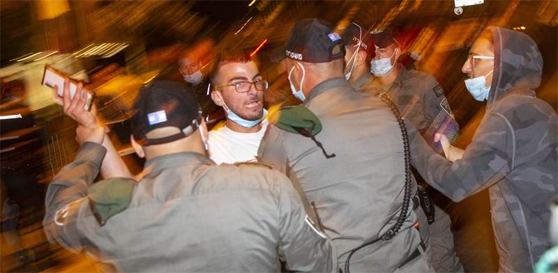 שוטרי מג"ב משתלטים על אדם שניסה לתקוף מפגינים / צילום: Ariel Schalit, Associated Press