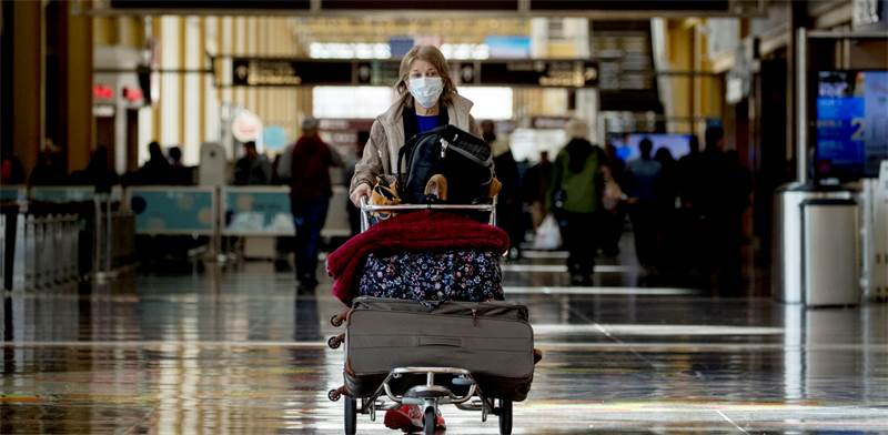 אישה עם מסכה בנמל התעופה רונלד רייגן בוושינגטון, ארה"ב / צילום: Andrew Harnik, AP
