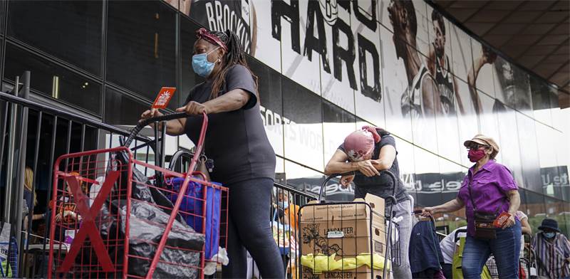 אנשים עומדים בתור לתרומות מזון בניו יורק / צילום: John Minchillo, AP