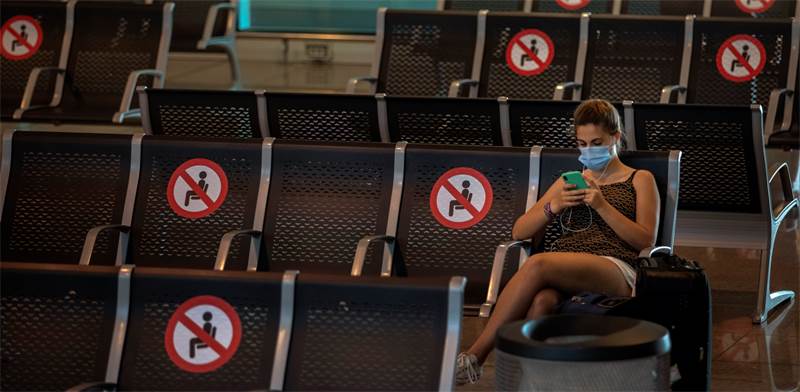 נוסעת בשדה התעופה בברצלונה. מגפת הקורונה פגעה קשה מאוד בענף התיירות / צילום: Emilio Morenatti, AP