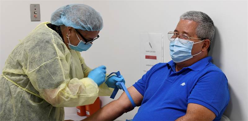 מתנדב בניסוי החיסון לקורונה של חברת מודרנה / צילום: Taimy Alvarez, AP