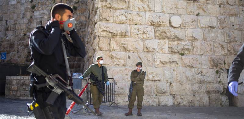 חיילים, שוטרים ומאבטחים עם מבכות פנים שומרים על הסגר בירושלים / צילום: Ariel Schalit, Associated Press