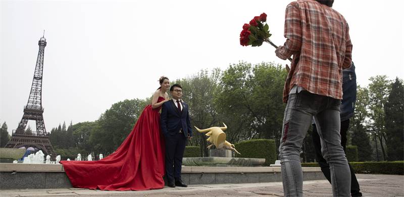 זוג סיני מצטלם לתמונות חתונה בפארק העולמי בבייג'ינג / צילום: Ng Han Guan, Associated Press