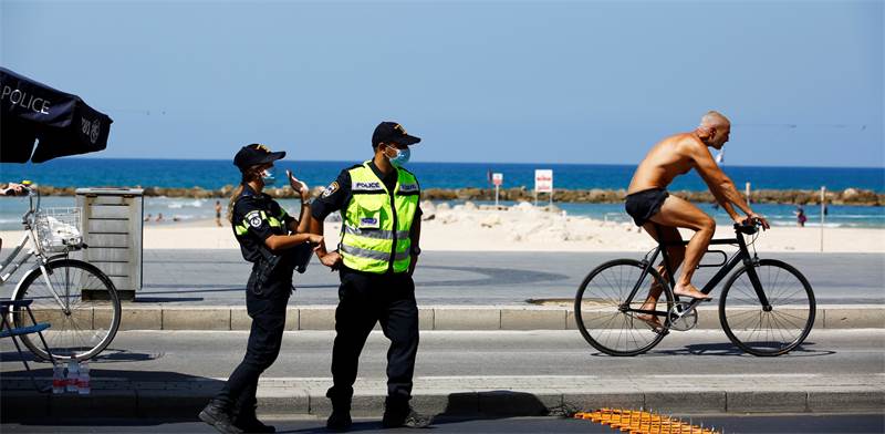 שוטרים בחוף הים בתל אביב לפני כניסת יום הכיפורים / צילום: Corinna Kern, רויטרס
