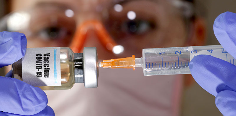 מדענית מחזיקה חיסון נסיוני נגד נגיף הקורונה / צילום: Dado Ruvic, רויטרס