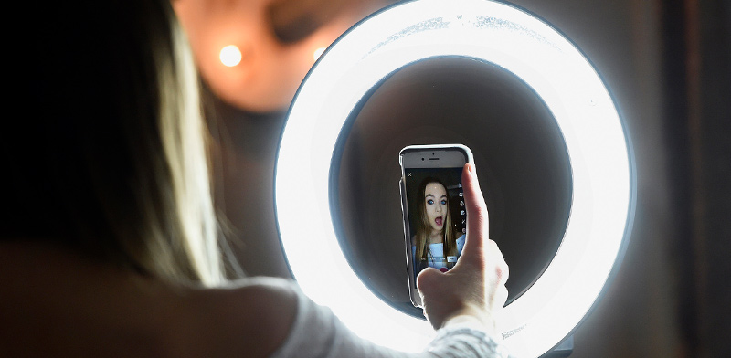 נערה מצטלמת כשהיא עושה ליפסינק ווידאו באפליקציית טיקטוק / צילום: Jessica Hill, Associated Press