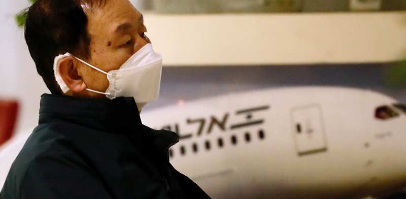 אחד הנוסעים הדרום-קוריאנים שנדבקו בקורונה מחכים בשדה התעופה בן-גוריון / צילום: Ariel Schalit, Associated Press