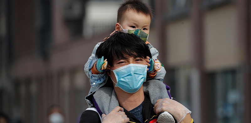 משפחה ברחובות בייג'ין הולכת ממוגנת מחשש להדבקות / צילום: Associated Press