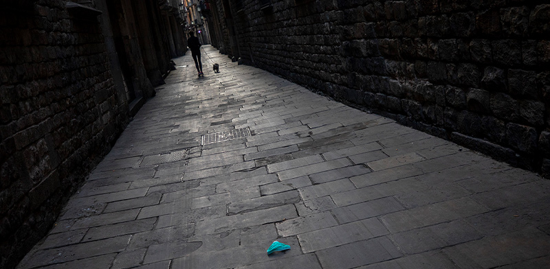 מסיכת מגן זרוקה על מרצפות אחת הסמטאות העמוסות של העיר העתיקה בברצלונה. כעת ריקה / צילום: Emilio Morenatti, Associated Press