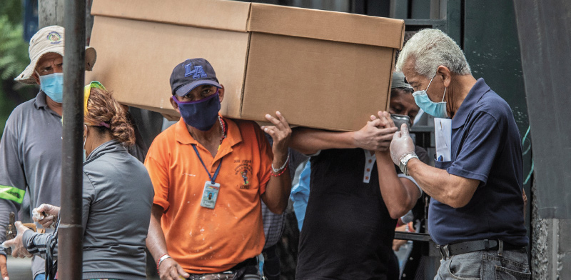אזרחי אקוודור נושאים ארון קבורה מקרטון בדרך לבית קברות בגוואייאקיל / צילום: Luis Perez, Associated Press