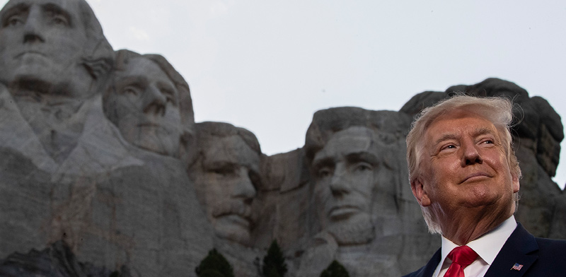 הנשיא טראמפ עומד ברקע פסלי ראשי הנשיאים של ארה"ב, של הר ראשמור המפורסם / צילום: Alex Brandon, Associated Press