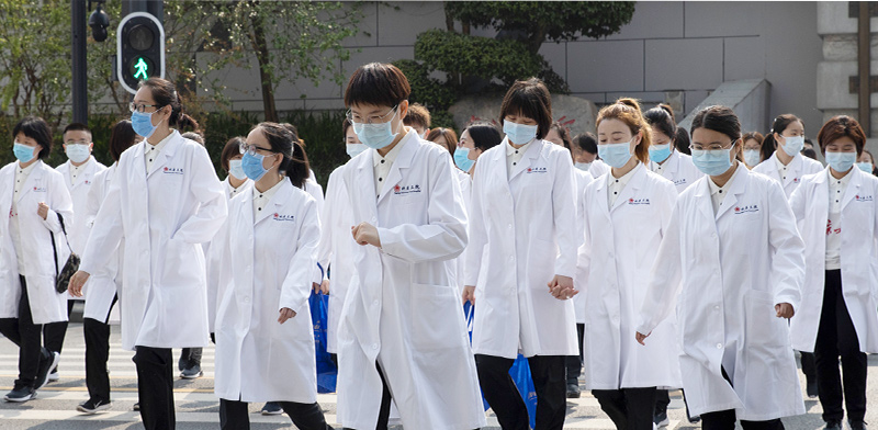 צוותים רפואיים בווהאן. רק ל־14% מהסינים יש מספיק חסכונות להתמודד עם מקרה חירום רפואי  / צילום: Ng Han Guan, Associated Press