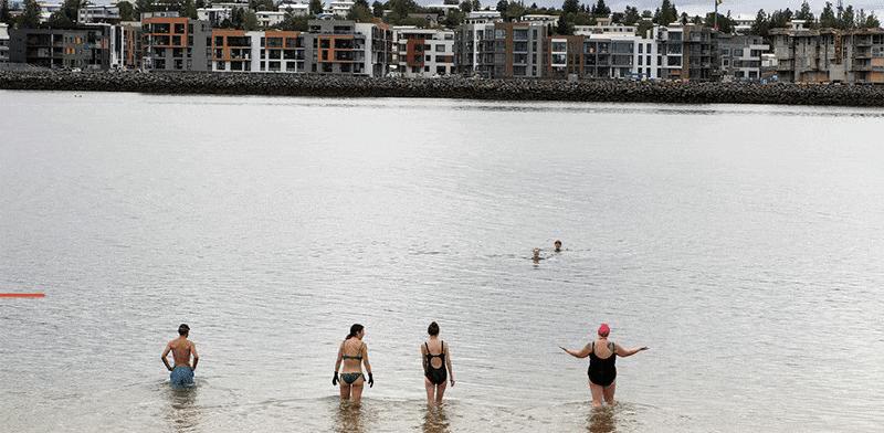 אנשים שוחים ברקע בירת איסלנד, ברייקיאוויק, אוגוסט. "הפוליטיקאים לא התערבו ולא הצליחו לקלקל" / צילום: ?rni Torfason, Associated Press