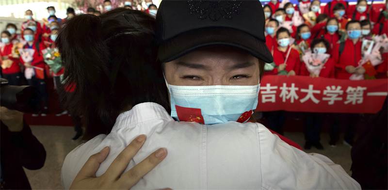 אישה בשדה התעופה בווהאן מתכוננת לחזור הביתה ביום הראשון לשחרור לאחר הסגר / צילום: AP