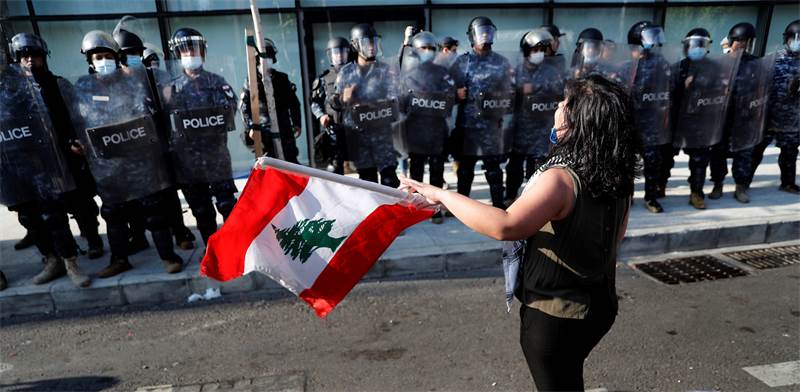 מגפינה בלבנון עומדת מול חיילים שעוטים מסכות בשל הקורונה / צילום: Hussein Malla, AP