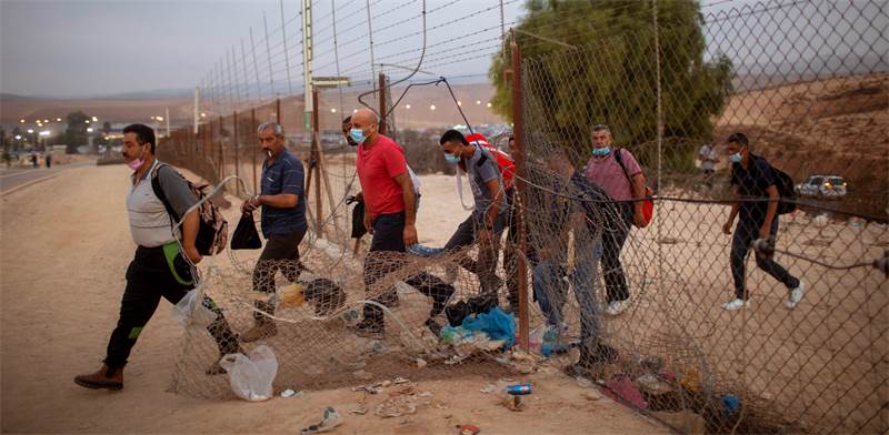 פועלים פלסטיניים חוצים את גדר ההפרדה בדרך לעבודה בישראל
צילום:PA
Oded Balilty
