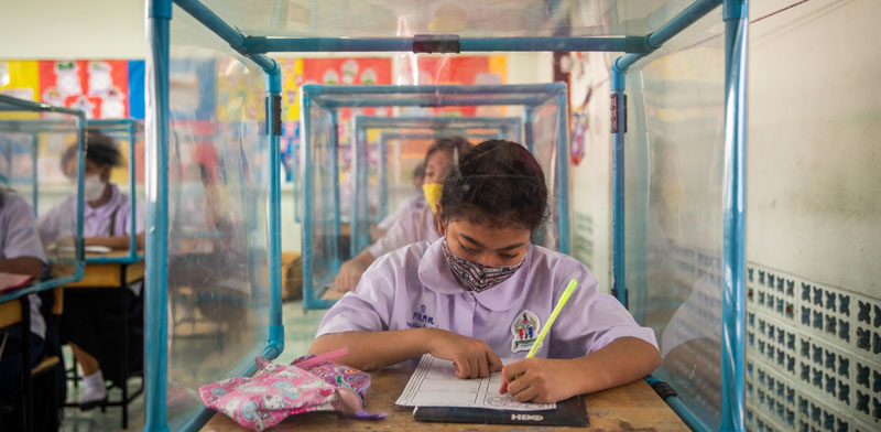 תלמידה בתאילנד יושבת מאחורי מסך מגן מפלסטיק / צילום: Gettyimages ישראל - Lauren DeCicca